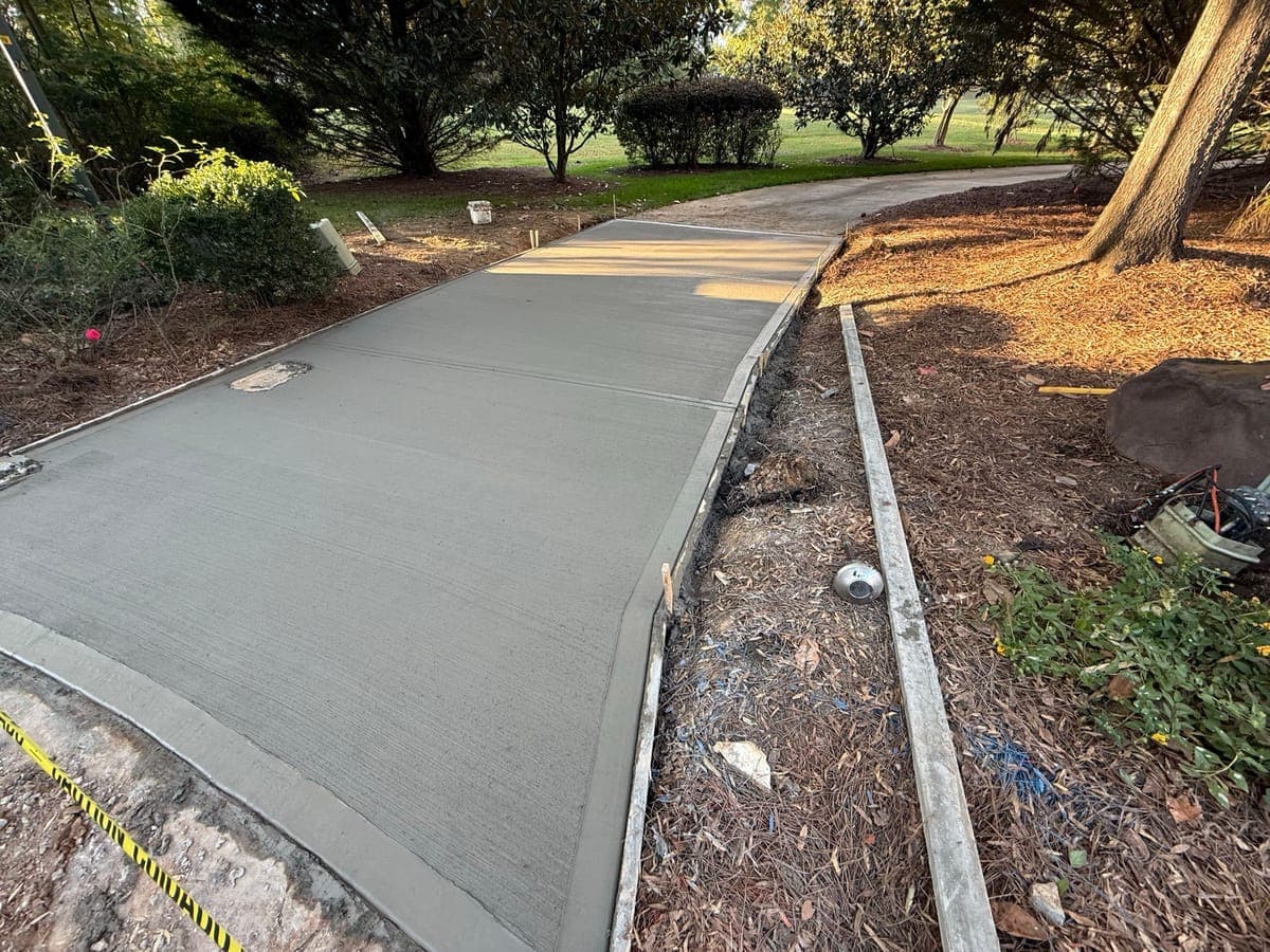 Newly poured Concrete Driveway Aprons in Charlotte, NC (Mecklenburg County) by Local Concrete Contractor — 4000 PSI mix, double-mat #4 rebar, broom-finish surface, 28-day full cure.