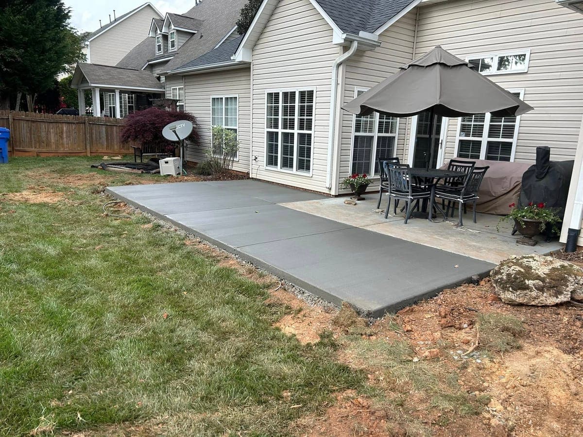 Newly poured Concrete Patio Additions in Charlotte, NC (Mecklenburg County) by Local Concrete Contractor — 4000 PSI mix, double-mat #4 rebar, broom-finish surface, 28-day full cure.