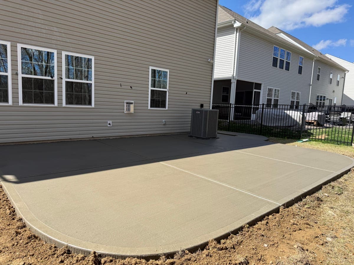 Concrete patio installation in Charlotte, NC — poured slab, tooled edges, broom-finish surface by Local Concrete Contractor.