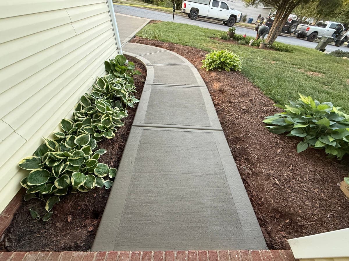 Concrete sidewalk installation in Charlotte, NC — poured pathway, saw-cut control joints, broom-finish surface by Local Concrete Contractor.