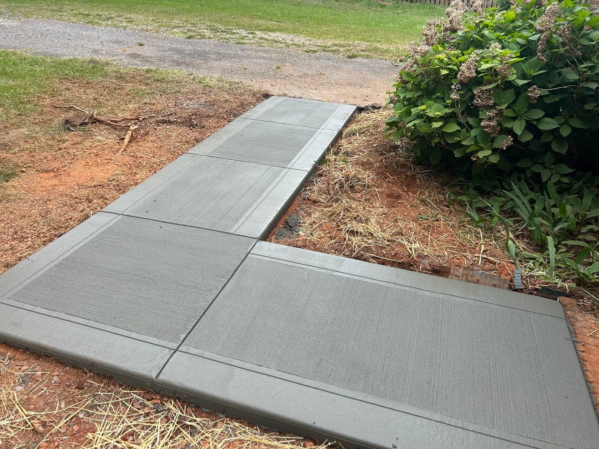 Newly poured Sidewalk Repair in Charlotte, NC (Mecklenburg County) by Local Concrete Contractor — 4000 PSI mix, double-mat #4 rebar, broom-finish surface, 28-day full cure.