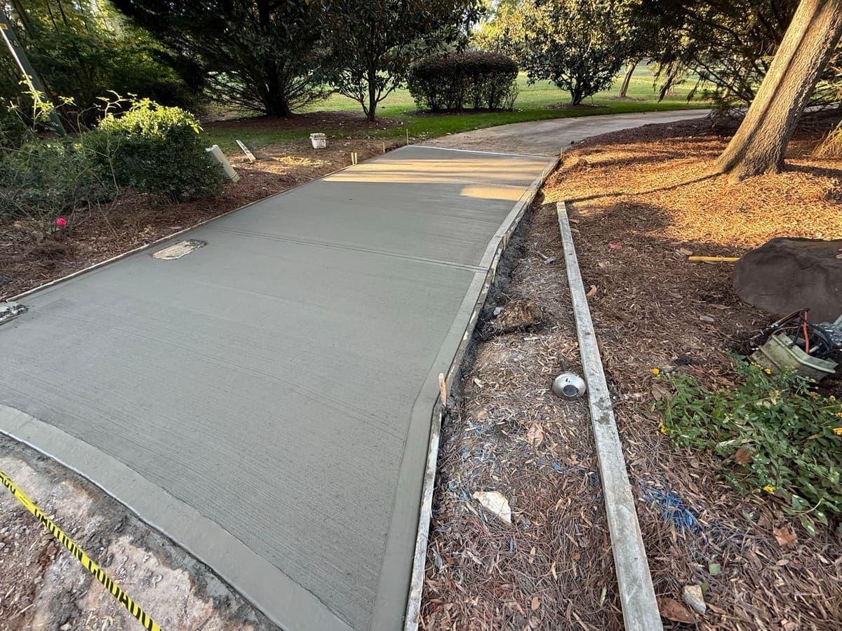 Concrete driveway apron in Matthews, NC — poured road-edge flare, control joints by Local Concrete Contractor.